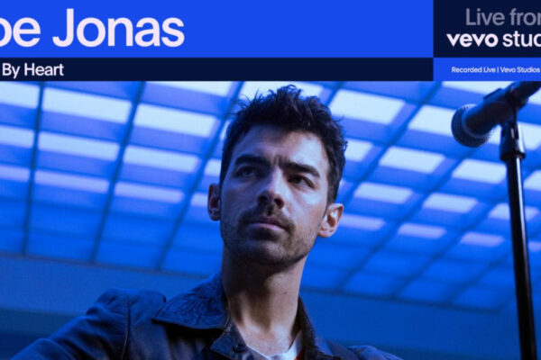 Joe Jonas Gets Heart By Heart With Vevo – And We’re Not Okay Joe Jonas headshot blue background