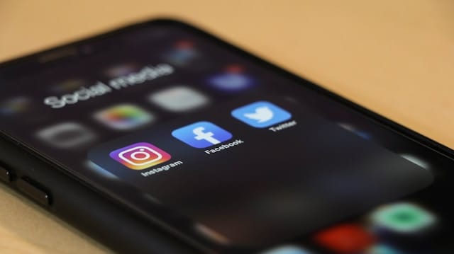 social media icons displayed on a black phone
