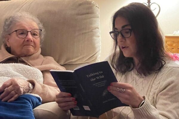 Grandmom WIlley sitting with Christy as she reads a poem on Christmas Eve 2024