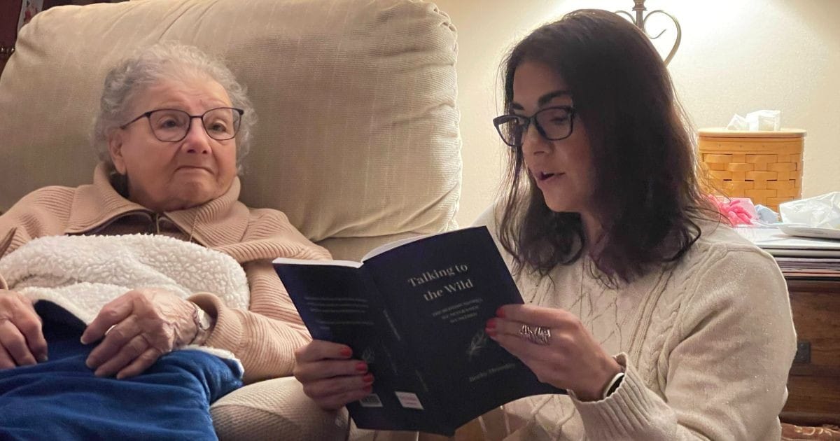 Grandmom WIlley sitting with Christy as she reads a poem on Christmas Eve 2024