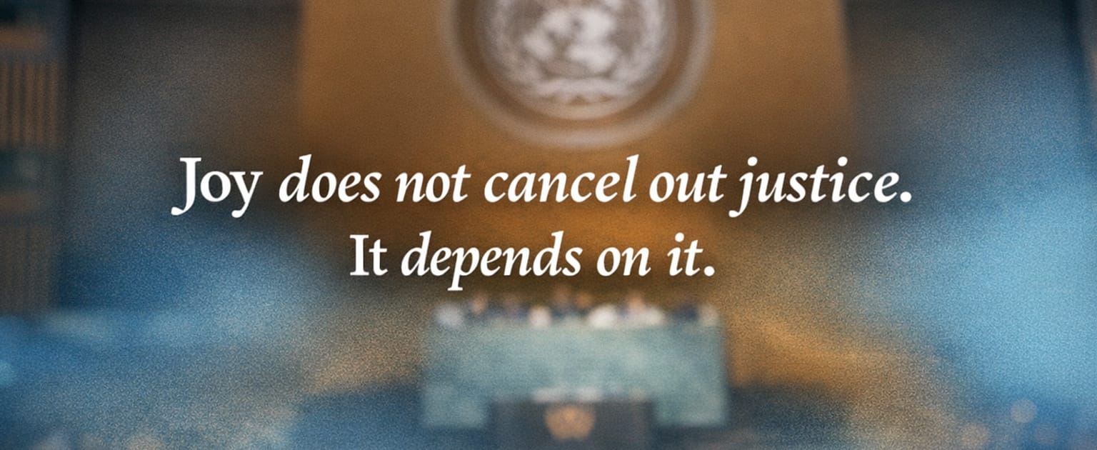 Blurred view of the United Nations General Assembly chamber with white text reading, “Joy does not cancel out justice. It depends on it.”