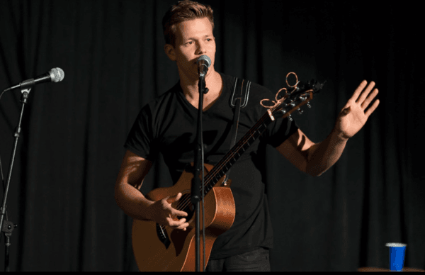 Tyler Ward performing live with an acoustic guitar onstage