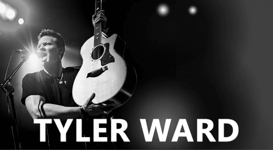 Black and white Tyler Ward on stage with an acoustic guitar